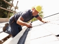 Roofer Working On Exterior Of New Home